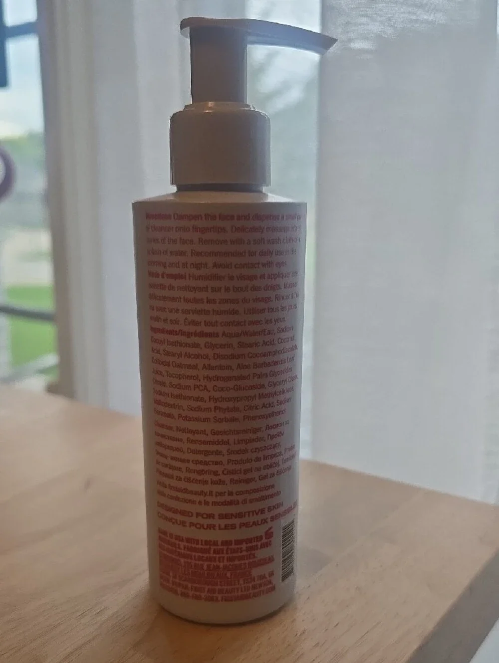 First Aid Beauty Moisturizer Bottle with White and Red Accents